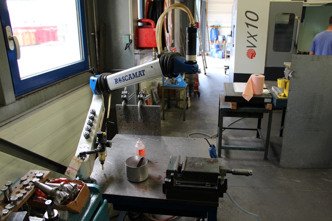 Pneumatic driller with arm